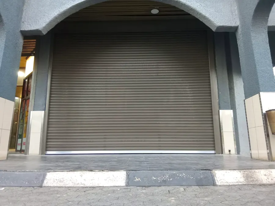 Arched shopfront secured with a roller shutter door