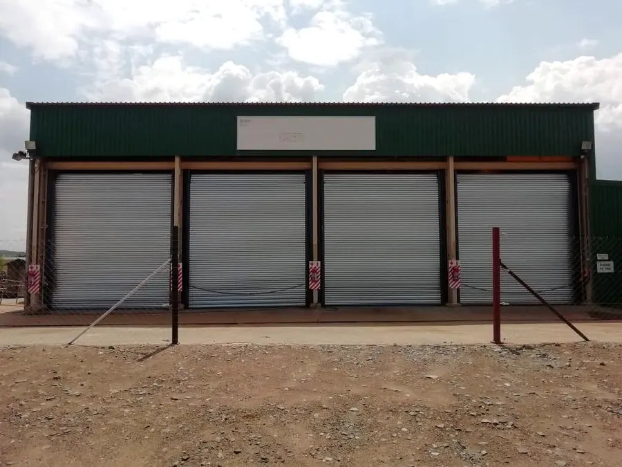 Four galvanised roller shutter doors on a storage building