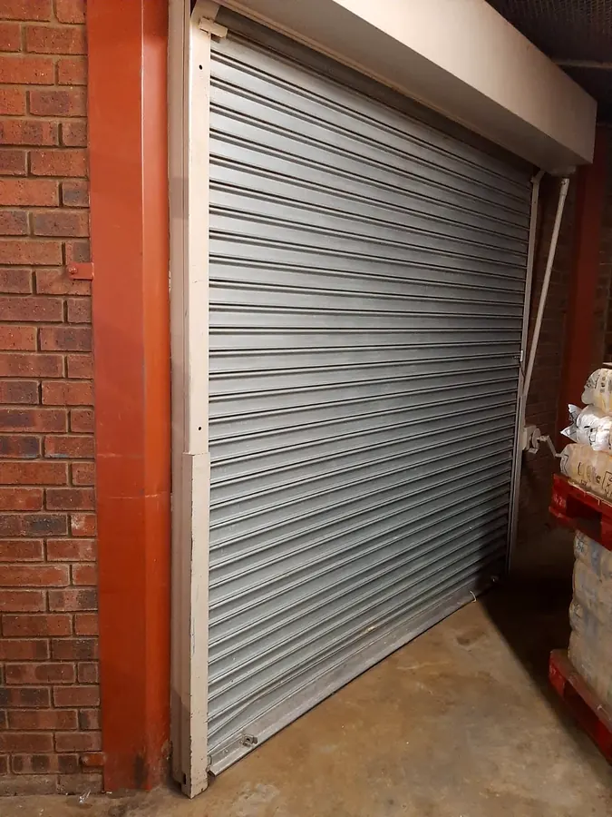 Galvanised roller shutter installed in a brick storage building