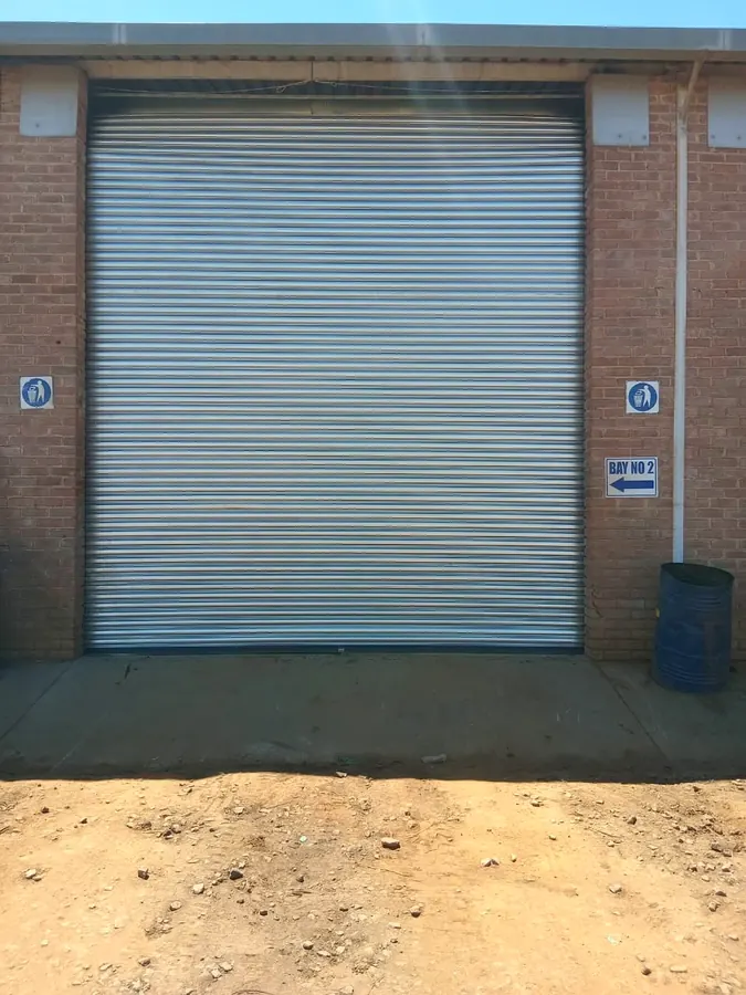 Galvanised roller shutter door on a brick warehouse