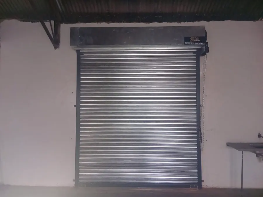 Galvanised roller shutter with hood mounted on an interior wall