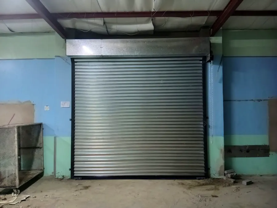 Galvanised roller shutter with hood inside a workshop