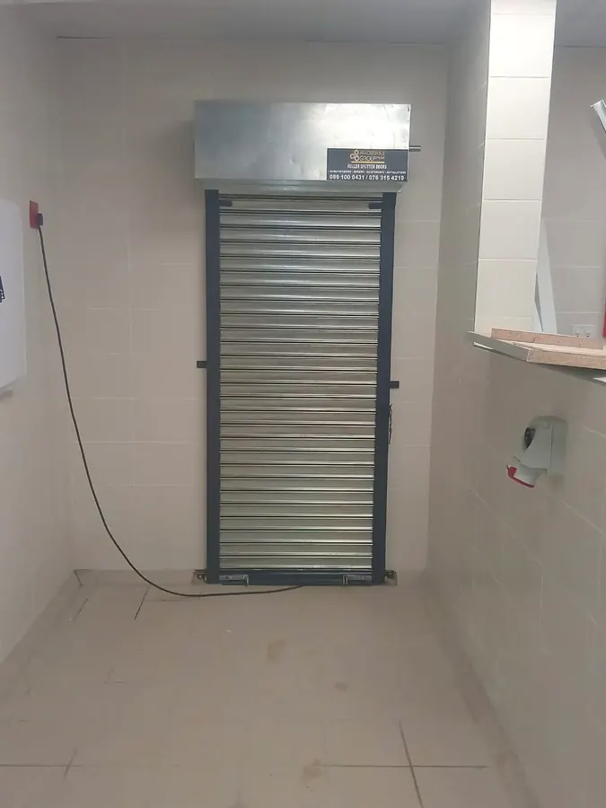 Narrow roller shutter with hood box fitted to a tiled store room