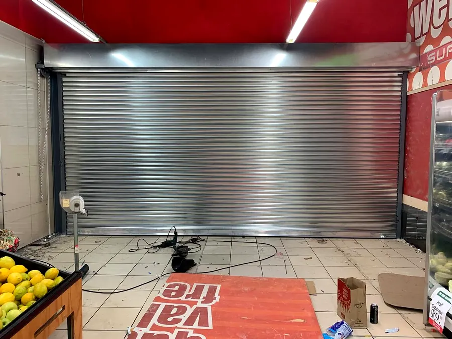 Galvanised roller shutter securing a supermarket counter